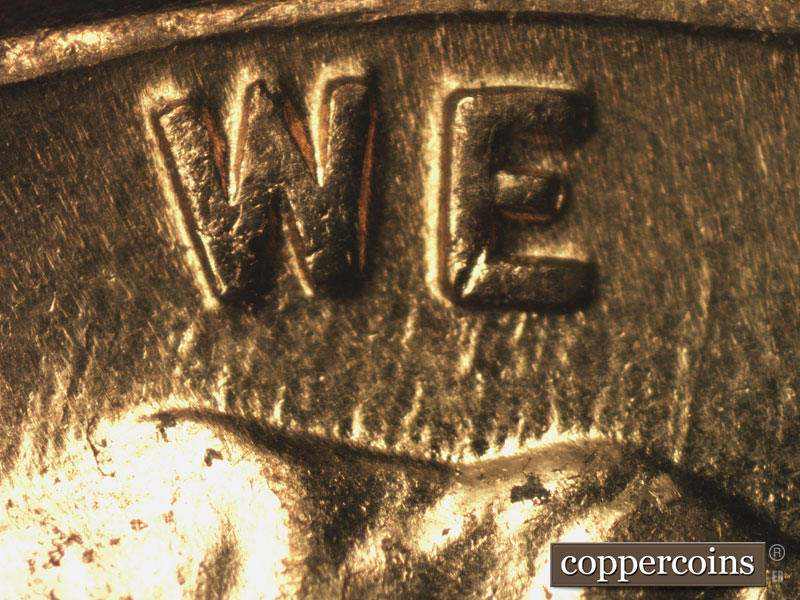 Die-stage B marker on 1960D•1MM•158 showing NNE die scratches from top of head into WE.
