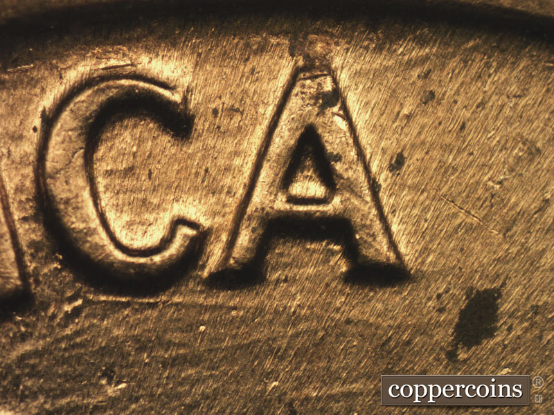 Die-stage B marker on 1960D•1MM•158 showing Die scratch undwer C in AMERICA.