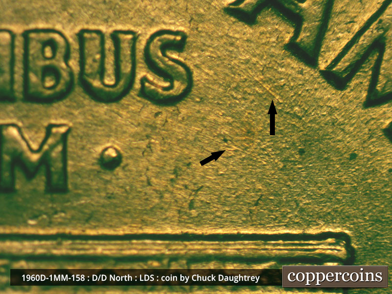 Die-stage D marker on 1960D•1MM•158 showing SE die gouge under first A in AMERICA.