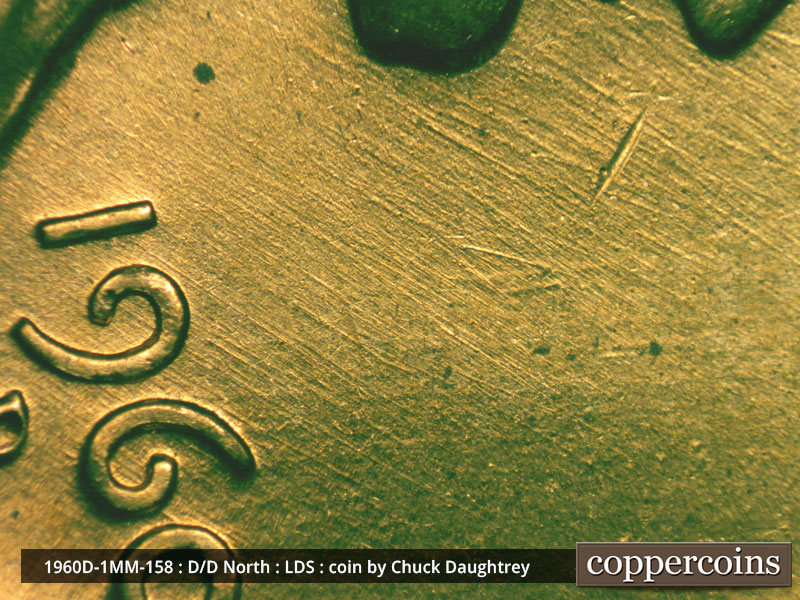 Die-stage D marker on 1960D•1MM•158 showing NE die scratches above date.