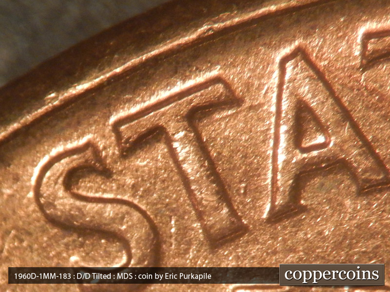 Die-stage B marker on 1960D•1MM•183 showing A die scratch under the right crossbar of the first T in STATES.