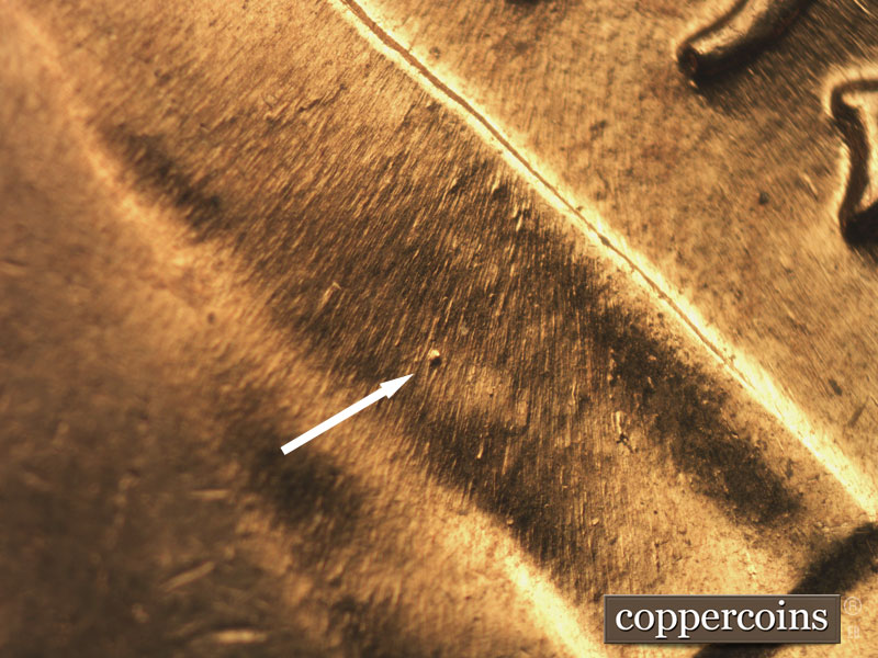 Die-stage C marker on 1960D•1MM•200 showing Die dot on lower lapel.