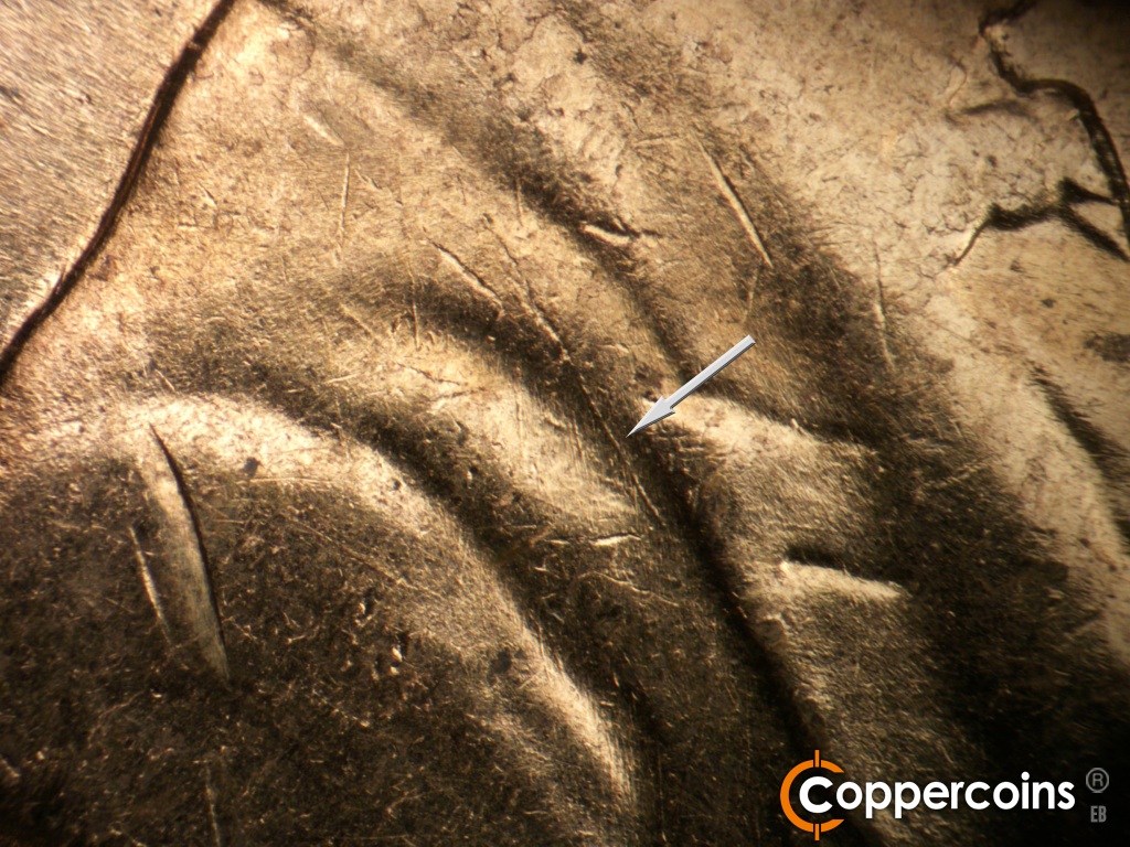 Die-stage B marker on 1960D•1MM•295 showing Heavy die scratch in jacket fold near lapel.