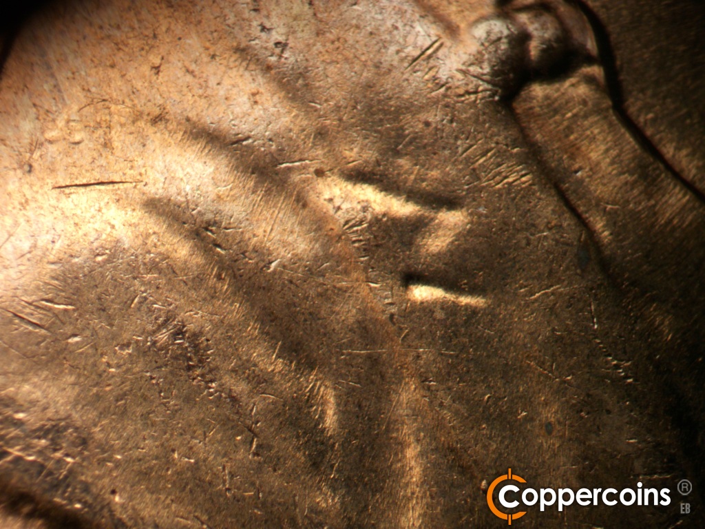 Die-stage C marker on 1960D•1MM•296 showing Die scratches in shoulder fold.