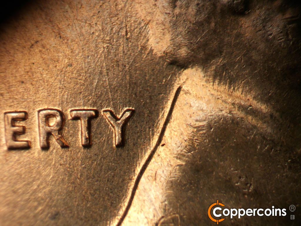 Die-stage C marker on 1960D•1MM•296 showing Die scratches through RTY in LIBERTY and on neck above collar.