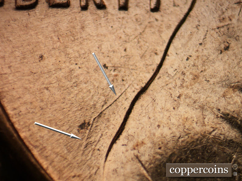 Die-stage C marker on 1961D•1MM•021 showing Heavy die scratch in field behind shoulder.
