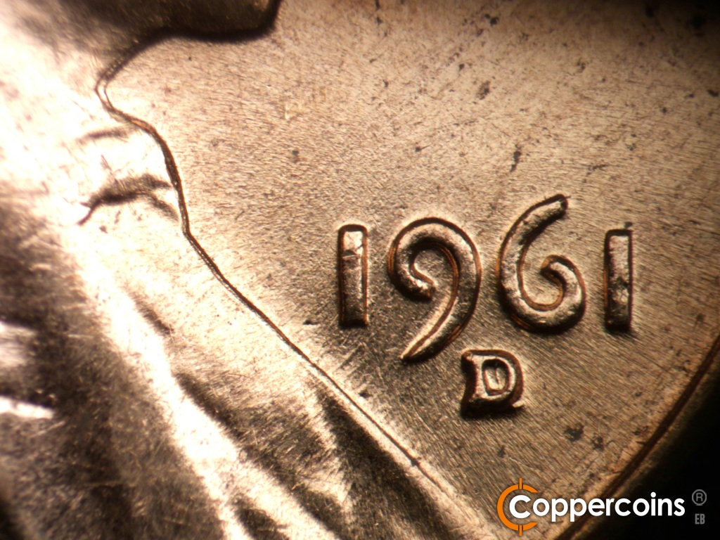 Die-stage B marker on 1961D•1MM•021 showing SW die scratches from date into lapel.
