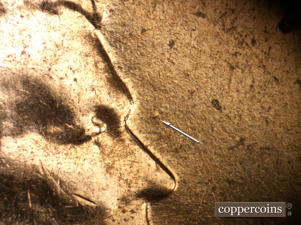 Die-stage B marker on 1961D•1MM•035 showing Die dot in front of bridge of nose.