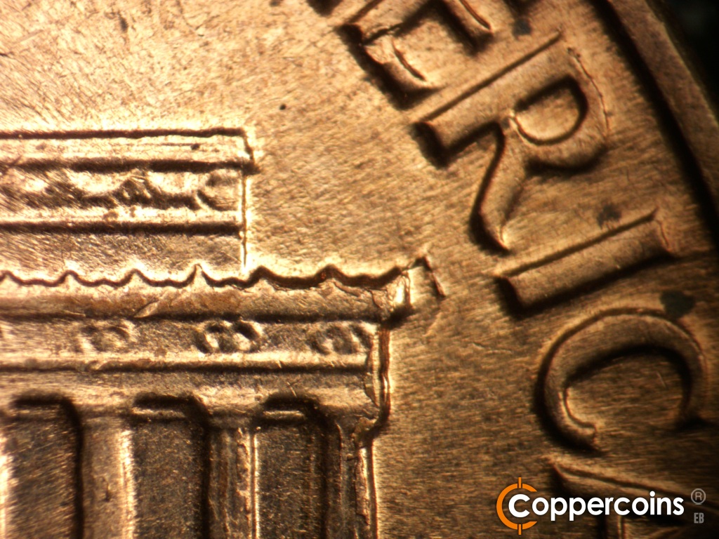 Die-stage C marker on 1961D•1MM•047 showing Die break at right cornice.