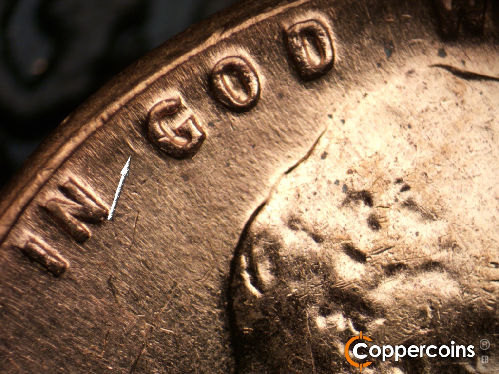Die-stage C marker on 1961D•1MM•060 showing Die scratch next to G in GOD.