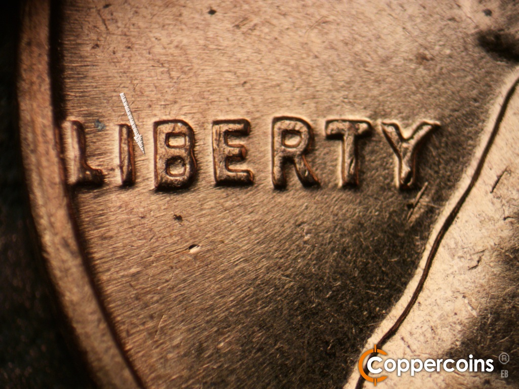 Die-stage C marker on 1961D•1MM•060 showing E-W die scratch between the I and B of LIBERTY.