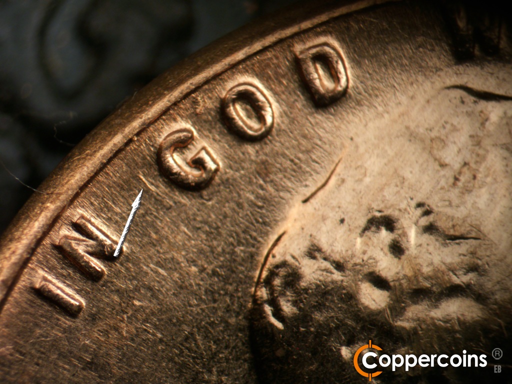Die-stage A marker on 1961D•1MM•060 showing Die scratch near G in GOD.