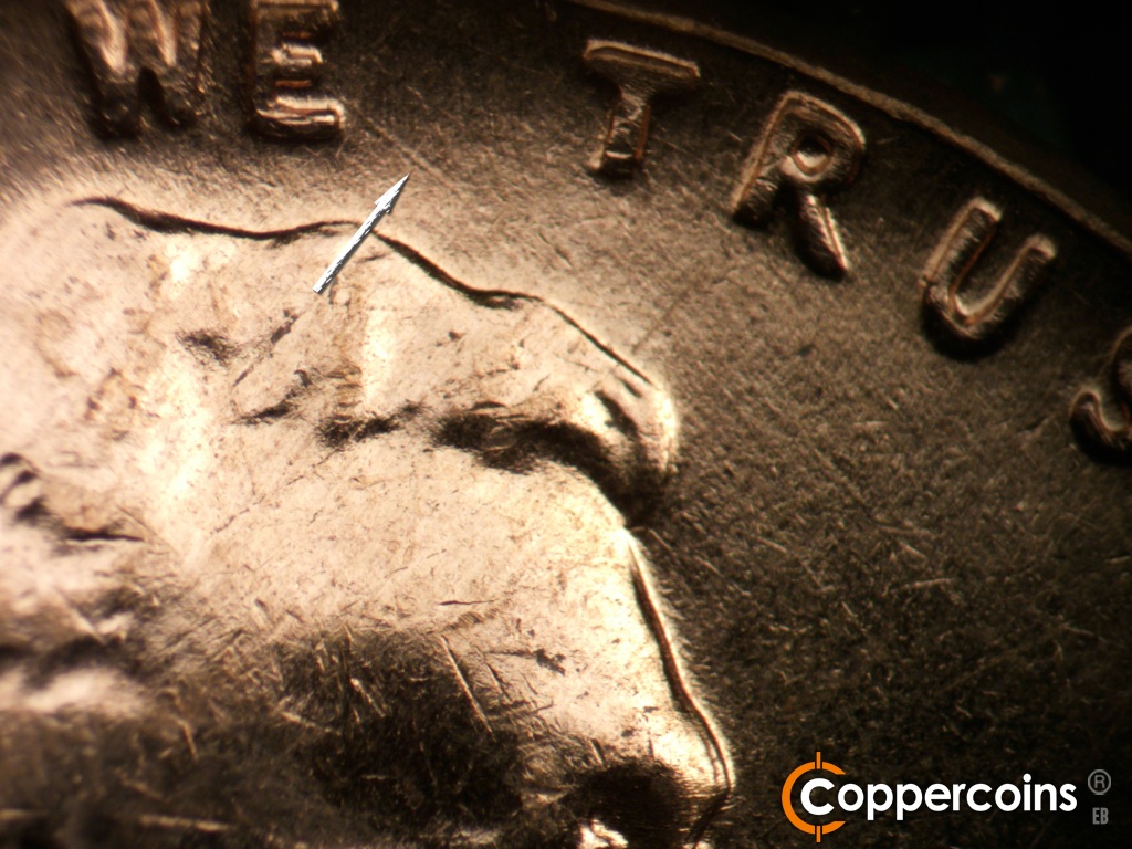 Die-stage A marker on 1961D•1MM•060 showing SE die scratch from lower E in WE.