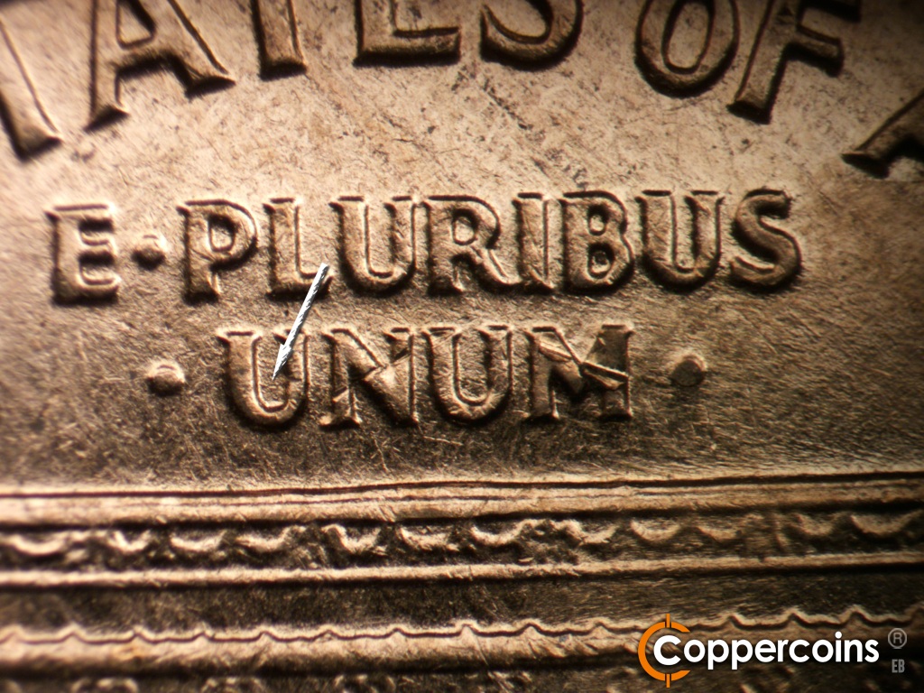 Die-stage A marker on 1961D•1MM•060 showing Small die scratch in first U in UNUM. ESE die scratches from bottom of BUS in PLURIBUS.
