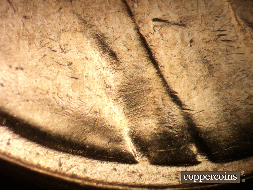 Die-stage B marker on 1961D•1MM•072 showing Die scratches in shoulder and jacket folds.