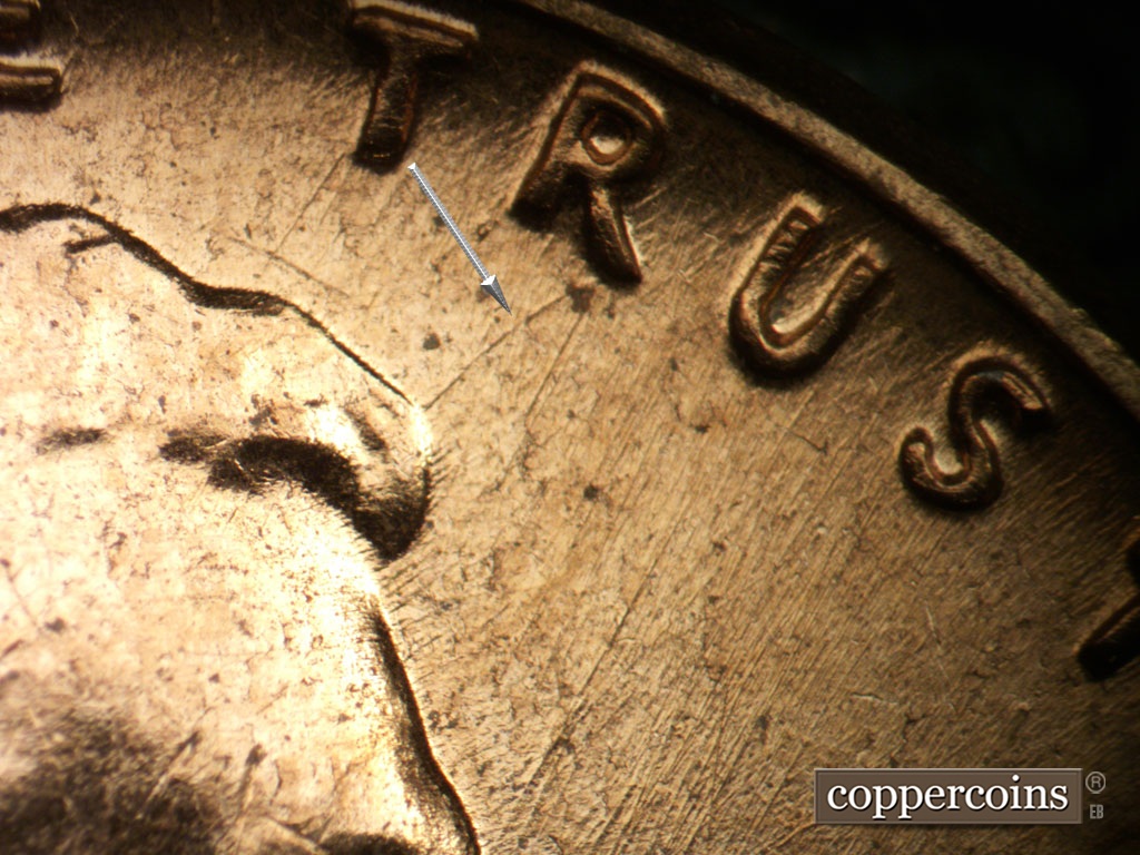 Die-stage B marker on 1961D•1MM•072 showing Die scratches through TRUST. Curved die scratch connect R in TRUST to the fron tip of hair.