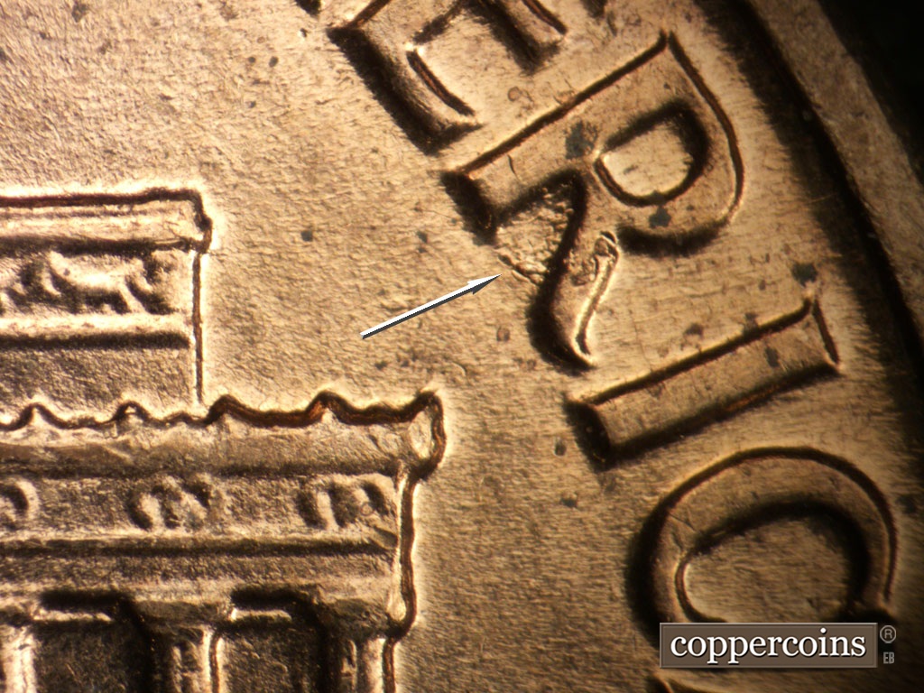 Die-stage B marker on 1961D•1MM•135 showing Die pitting in R of AMERICA.