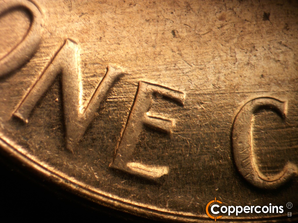 Die-stage C marker on 1961D•1MM•139 showing E/W die scratches through ONE.