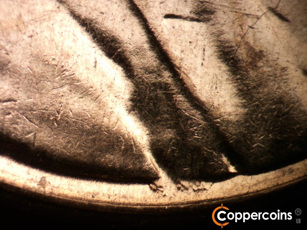 Die-stage B marker on 1961D•1MM•140 showing Heavy die gouge between rim and jacket.