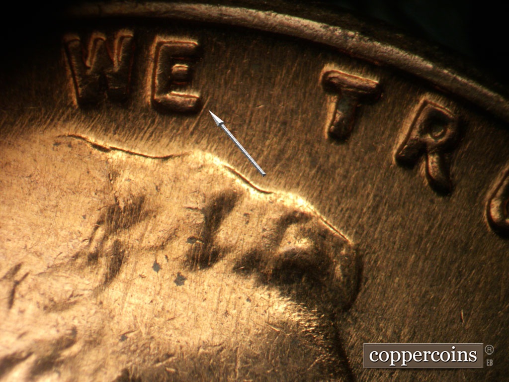 Die-stage A marker on 1962D•1MM•008 showing NE die scratch near E in WE.