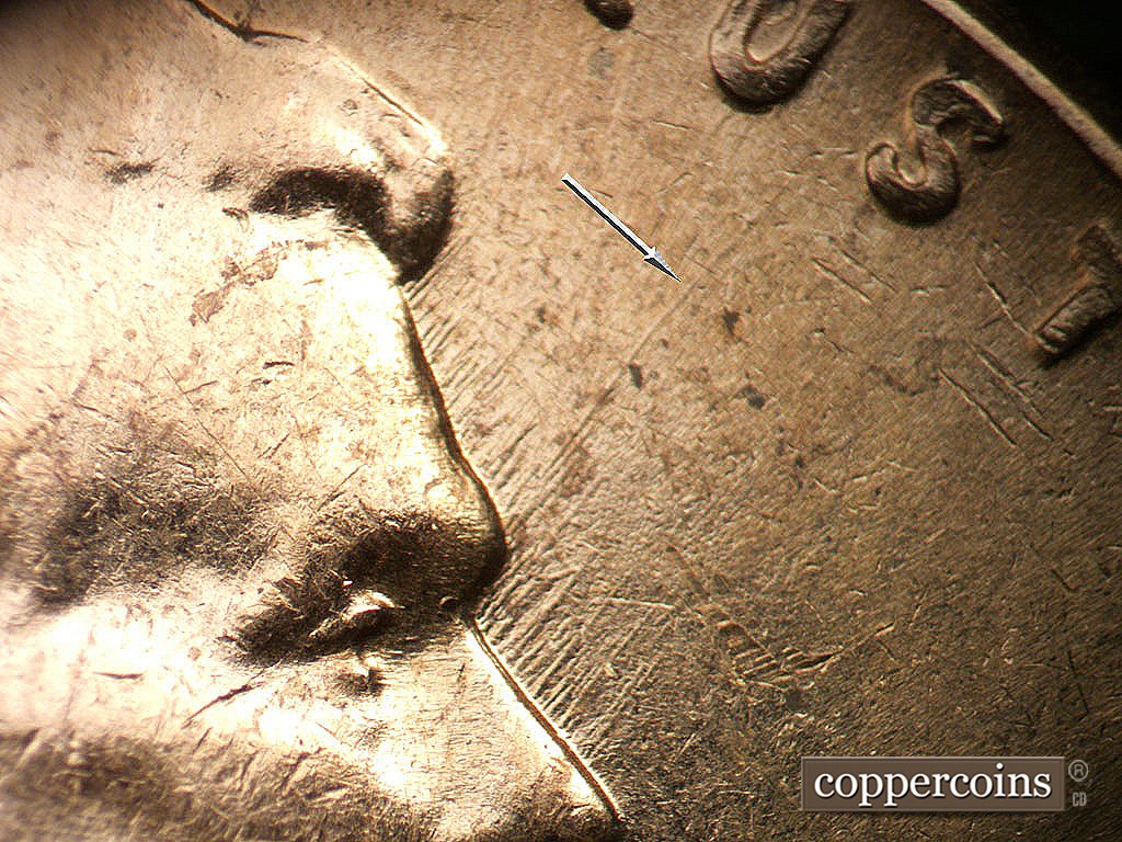 Die-stage B marker on 1962D•1MM•038 showing NE die scratches from brow including one that ewxtends between US in TRUST.