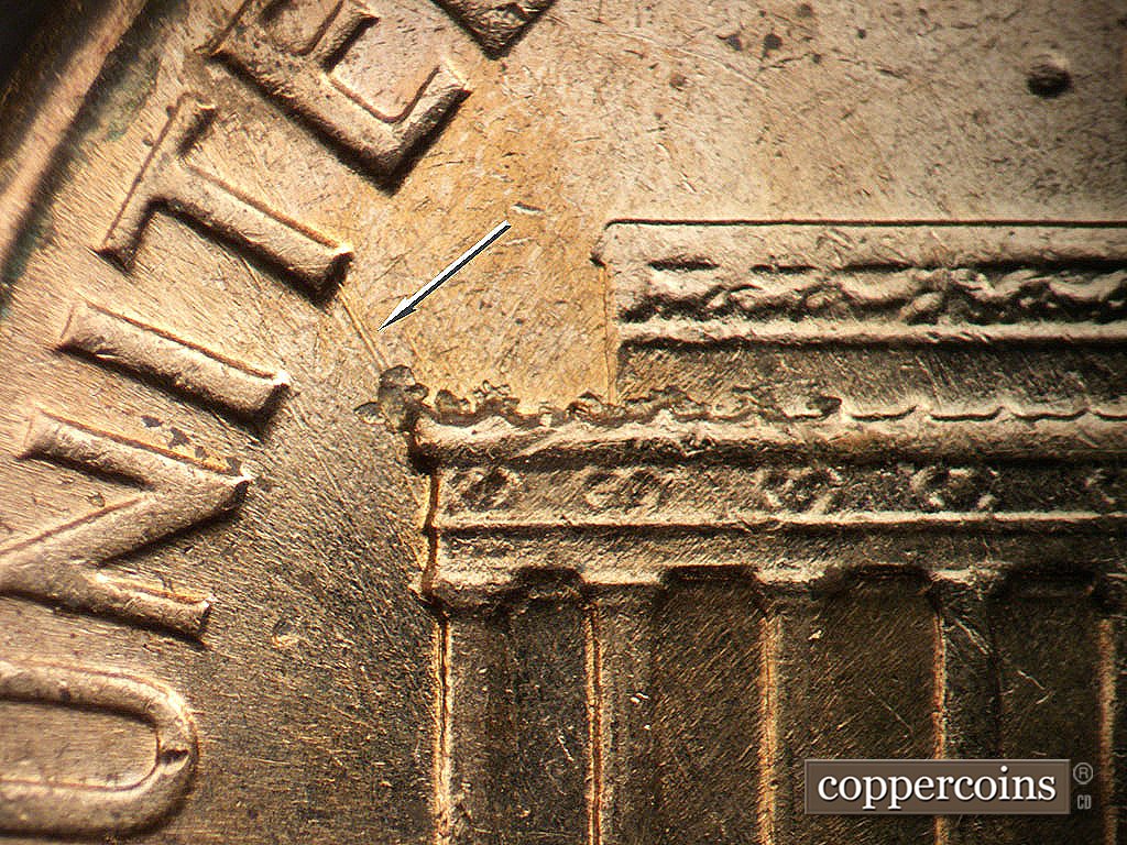 Die-stage B marker on 1962D•1MM•038 showing Nw die scratch connect left cornice to bottom of T in UNITED.