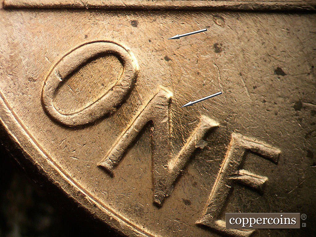 Die-stage B marker on 1962D•1MM•038 showing NNW die scratch from leg of N in ONE to base.