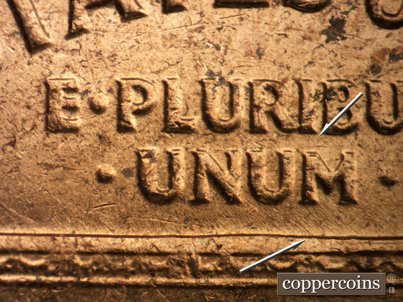 Die-stage B marker on 1963D•1DO•017 showing A die scratch above the M in UNUM and northwest-to-southeast die scratches extend under UNUM to the Memorial.
