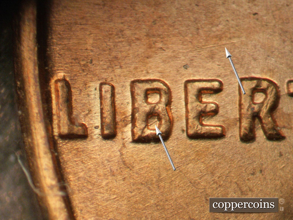 Die-stage B marker on 1963P•1DO•039 showing NE die scratch in lower B of LIBERTY. ENE die scratch above ER in LIBERTY.