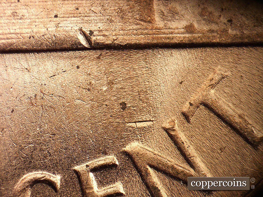 Die-stage C marker on 1964D•1MM•005 showing N/S die scratches under right base into NT in CENT.