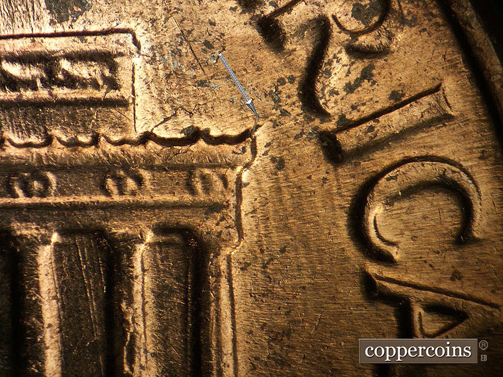Die-stage B marker on 1964D•1MM•014 showing Small die crack at right cornice.