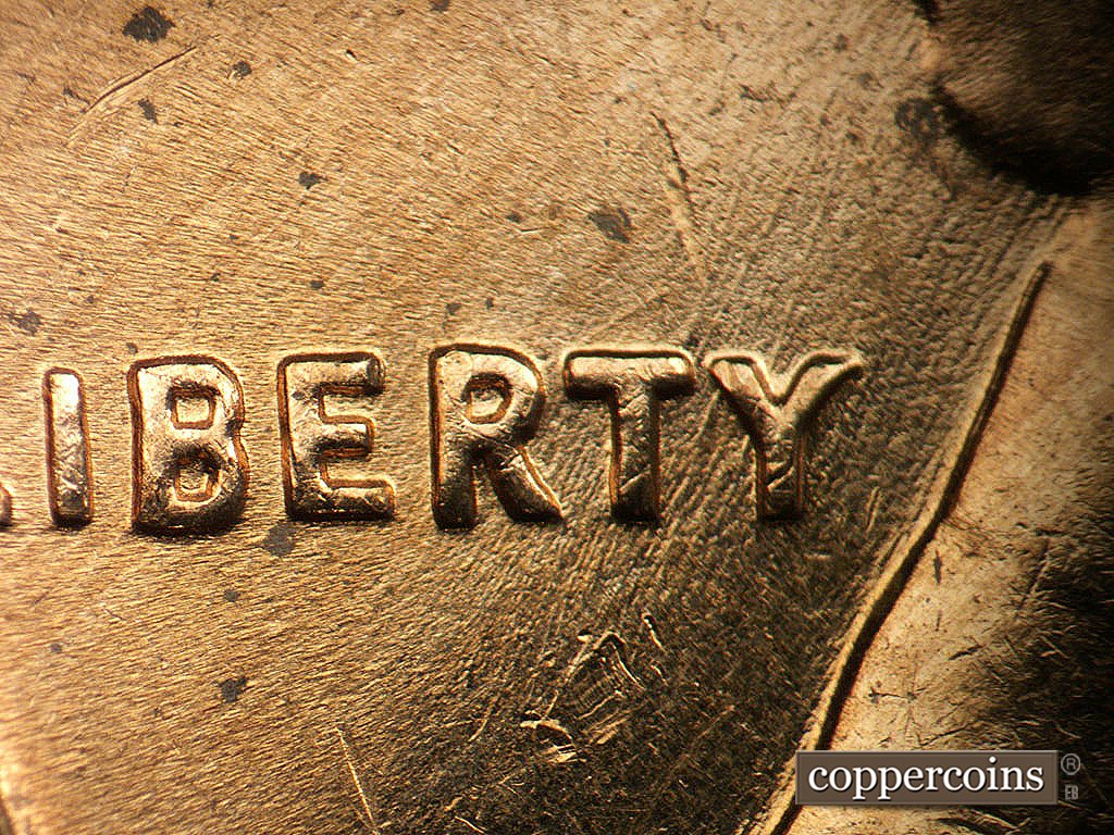 Die-stage B marker on 1964D•1MM•040 showing Die scratches through LIBERTY.
