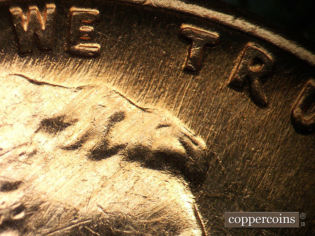 Die-stage B marker on 1964D•1MM•040 showing NNE die scratches above hair.