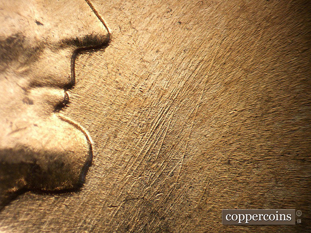 Die-stage B marker on 1964D•1MM•040 showing NE die scratches in front of mouth and beard.