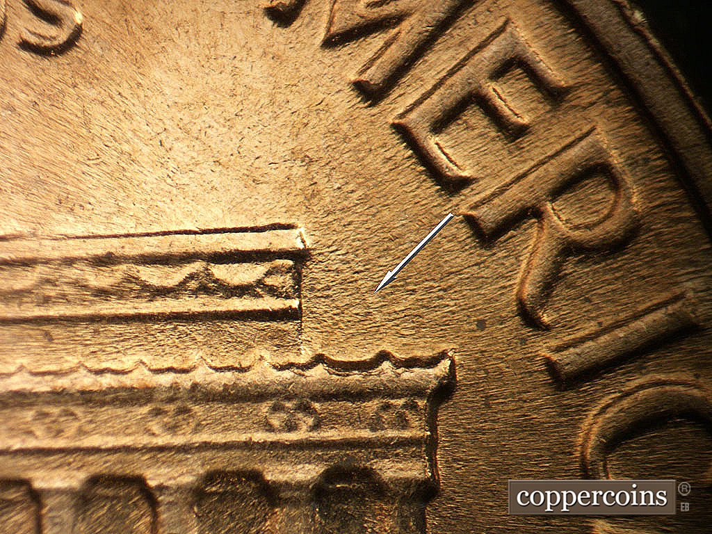 Die-stage B marker on 1964D•1MM•040 showing Light NNW die scratches above right cornice.