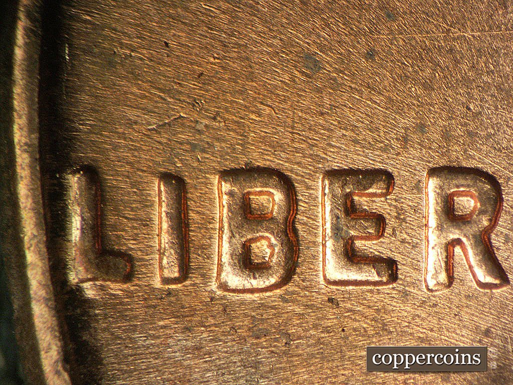 Die-stage B marker on 1964P•1DO•019 showing Doubling shows as extra bar from bottom of L in LIBERTY.