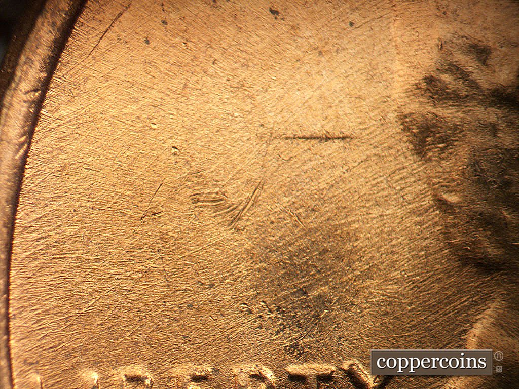 Die-stage B marker on 1971D•1MM•021 showing Die scratches behind head.