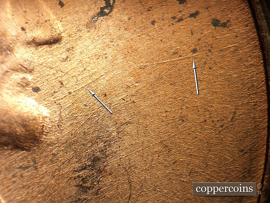 Die-stage B marker on 1971D•1MM•021 showing Die scratches in front of face.