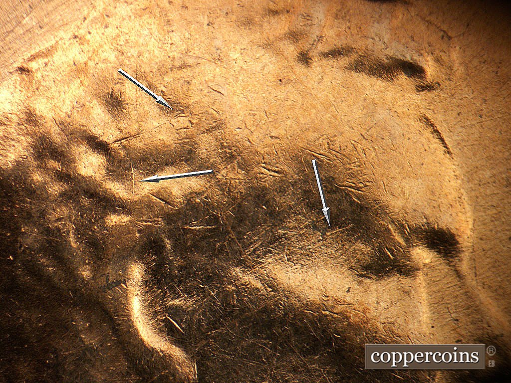 Die-stage B marker on 1971D•1MM•021 showing Light die crack above ear and in hair. SW die scratch scross temple.