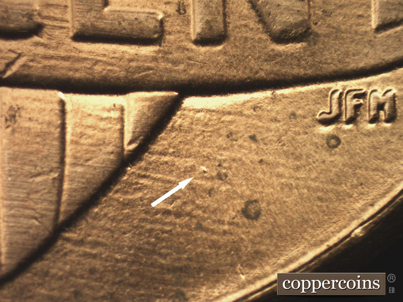Die-stage B marker on 2015P•1DR•001 showing A die dot south of the banner and east of the shield.