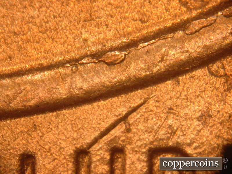 Die-stage C marker on 2016P•1DO•004 showing A larger chip on the top of the shield above the U.