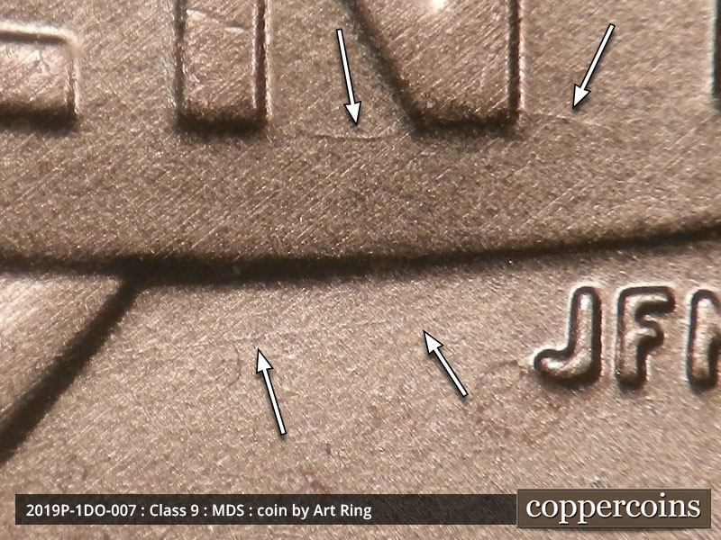 Die-stage B marker on 2019P•1DO•007 showing A die crack though the bottom of the N and a horizontal die scratch bellow the banner.