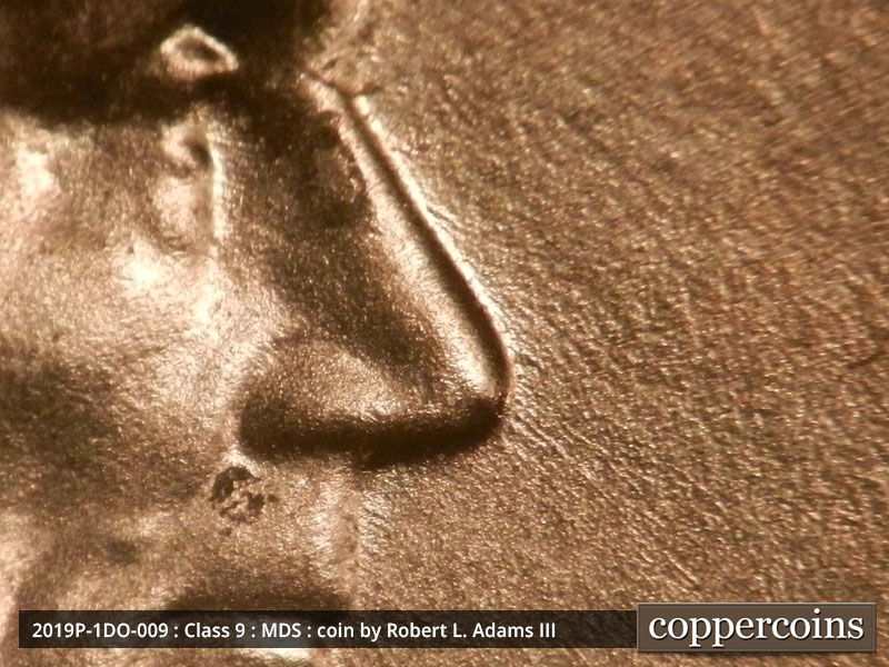Die-stage B marker on 2019P•1DO•009 showing Small die scratches run southeast from Lincoln's nose.