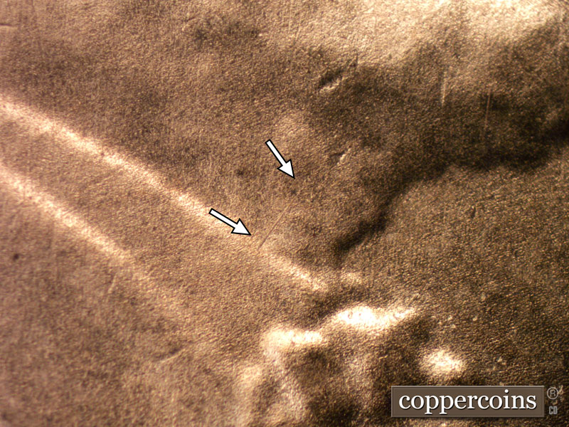 Die-stage B marker on 2020D•1DR•001 showing A diagonal die scratch shows on the adam's apple in Lincoln's throat.