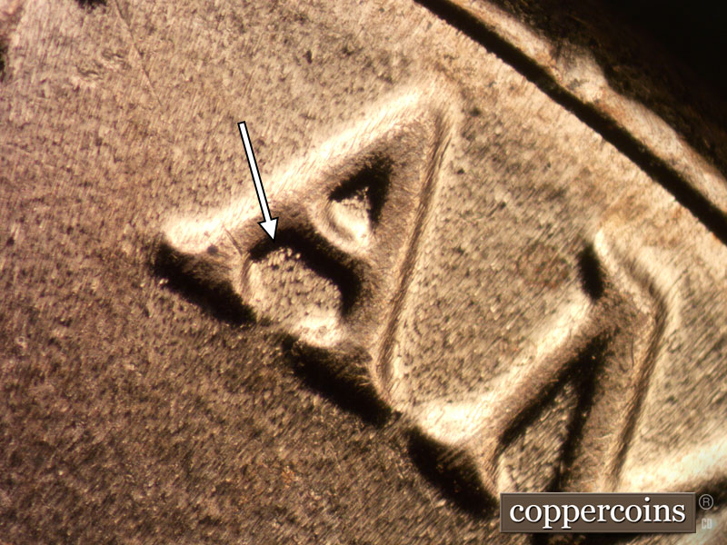 Die-stage B marker on 2020D•1DR•003 showing Die dot damage shows inside the lower half of the first A of AMERICA.