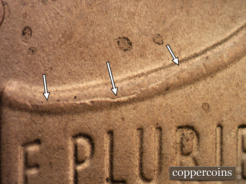 Die-stage B marker on 2020D•1DR•003 showing A die crack runs along the top of the shield's left upper border.