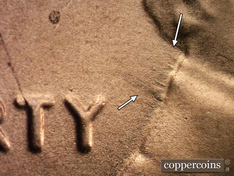Die-stage B marker on 2020D•1DR•003 showing Linear die damage shows on the back of the head.