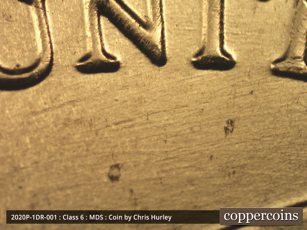 Die-stage B marker on 2020P•1DR•001 showing Die scratches run through and inside of the left half of the design.