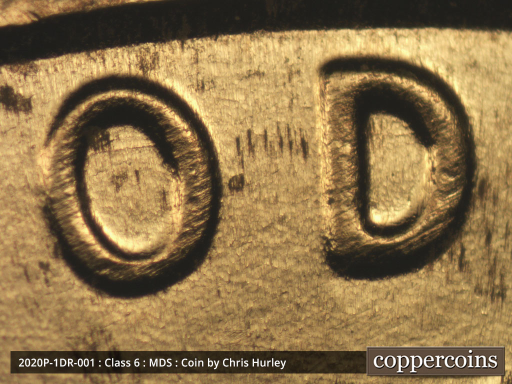 Die-stage B marker on 2020P•1DR•001 showing A heavier and sharper die scratch shows inside the O and D of GOD.