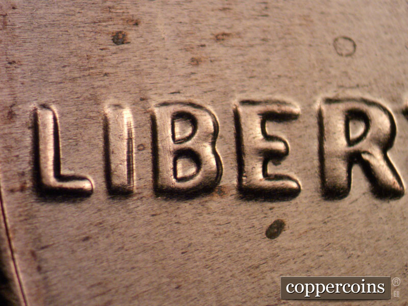 Die-stage C marker on 2021P•1DO•003 showing Extra thickness on ERTY in LIBERTY.